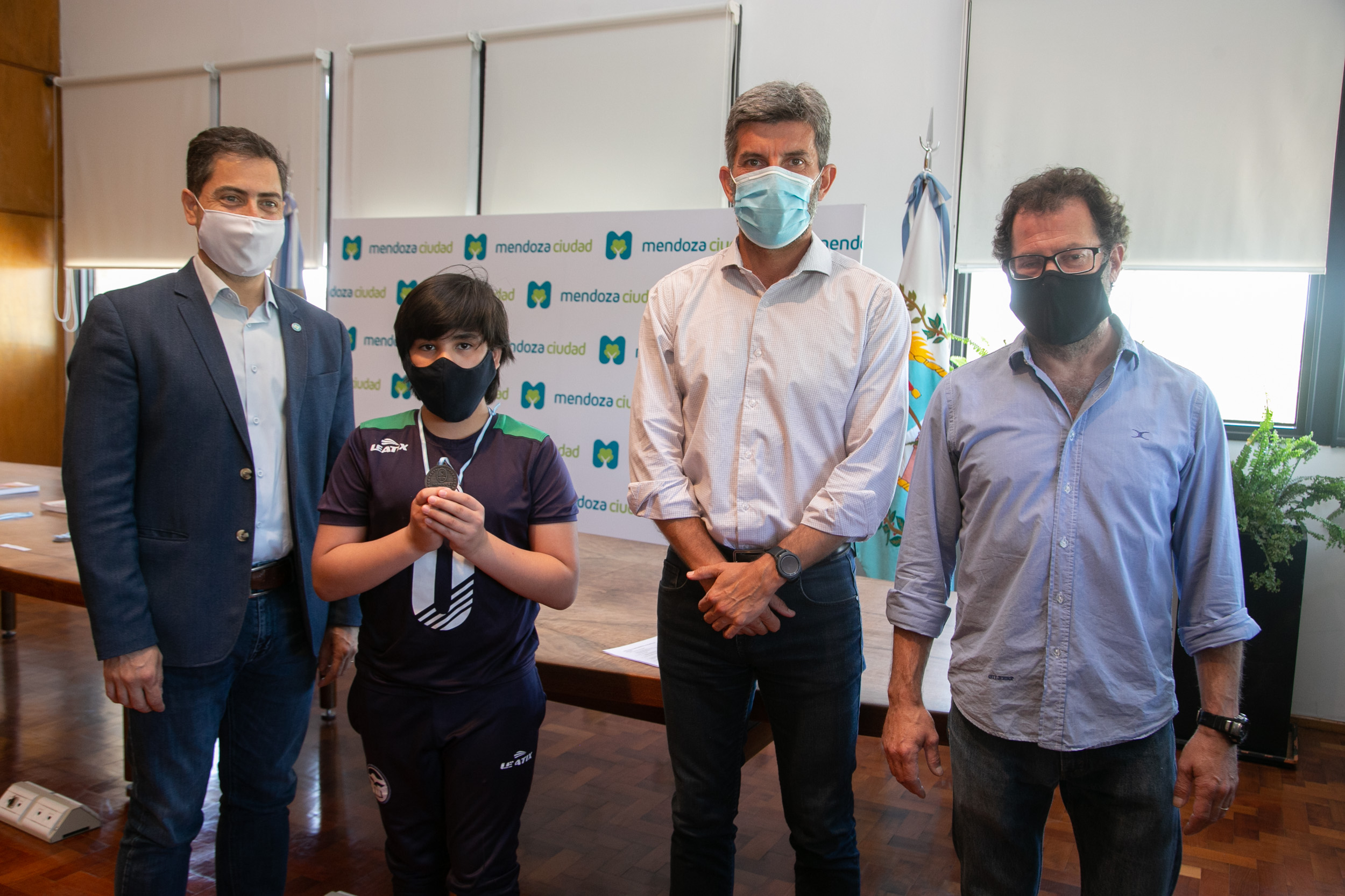 Rodrigo Olmedo, Ulpiano Suarez y Fernando Previtera posan con el pequeño Dante Lázaro, ganador en la divisional sub 12.